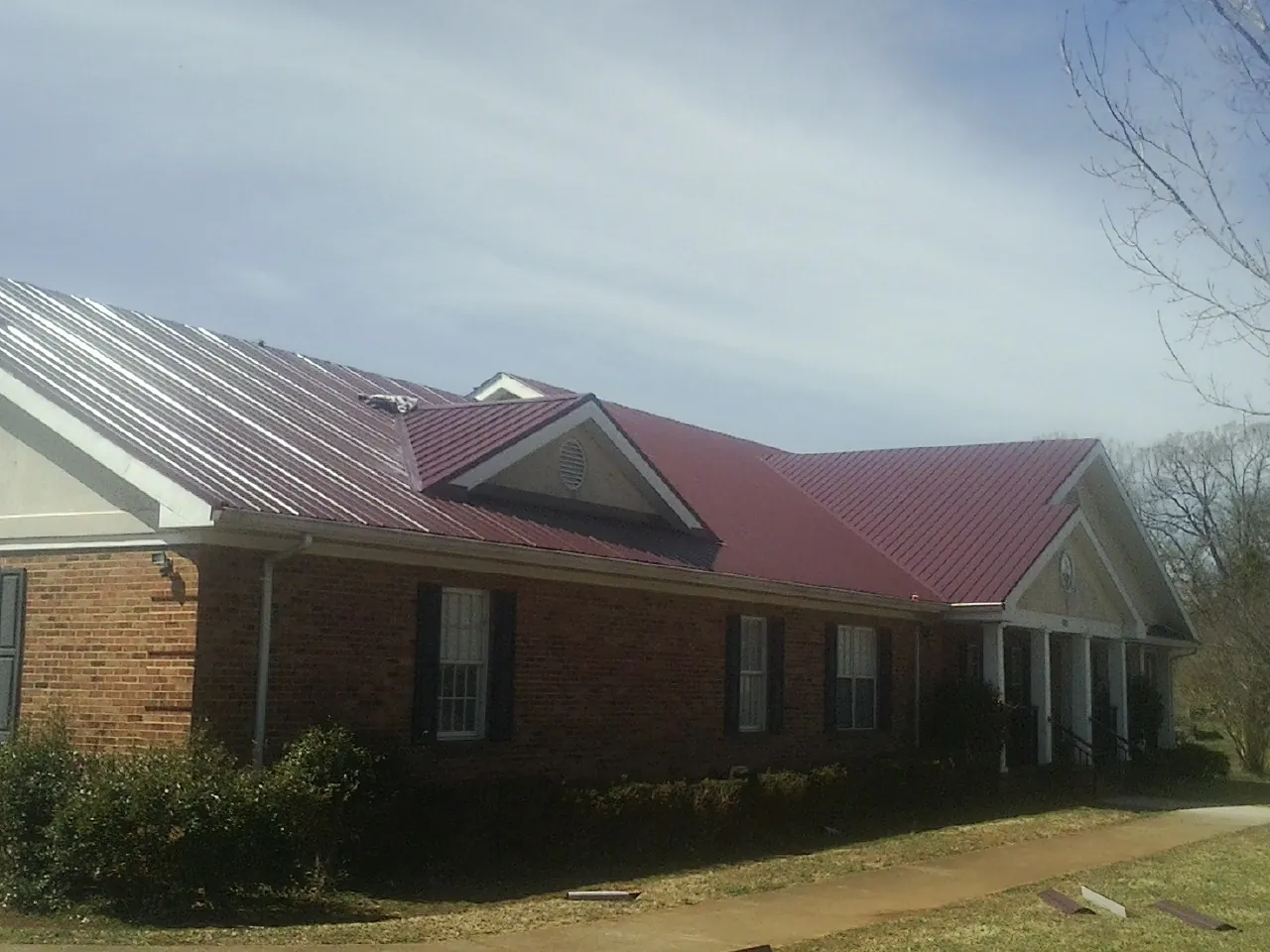 Red metal roof with gabled entries on a long brick building in Benton Harbor