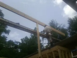 Carpenter setting a ridge beam over a new addition frame — Ice Dam Removal by Roofing Brothers in Benton Harbor