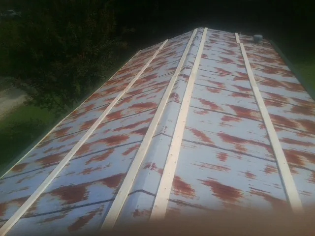 Rusted metal roof panels with new wood purlins before replacement — Storm Damage Roof Repair in Benton Harbor by Roofing Brothers