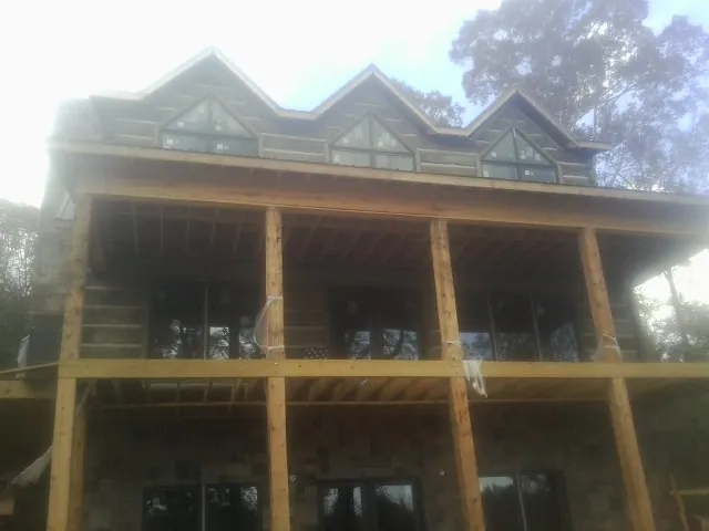 Dormers and porch framing on a large log home under construction — Roof Coating work by our crew in Benton Harbor