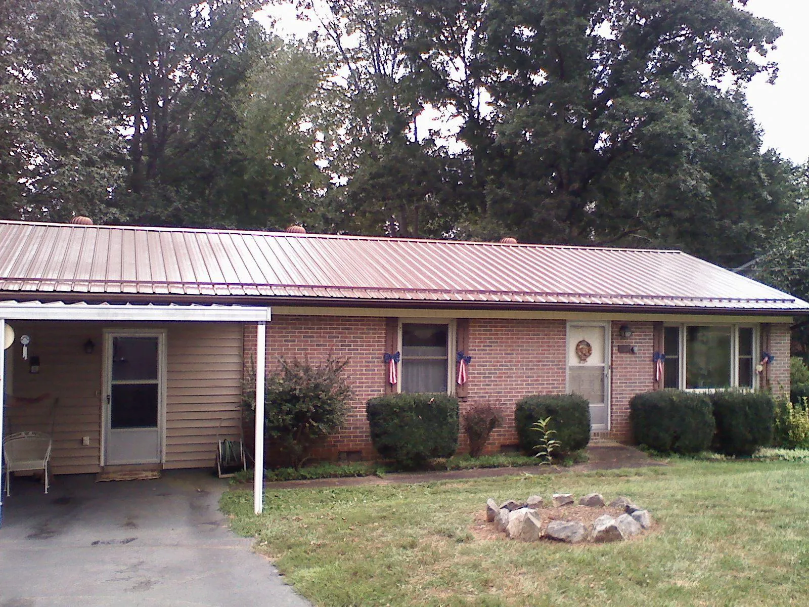 Bronze metal roof and carport on a brick ranch home — Roof Repair work by our crew in Benton Harbor