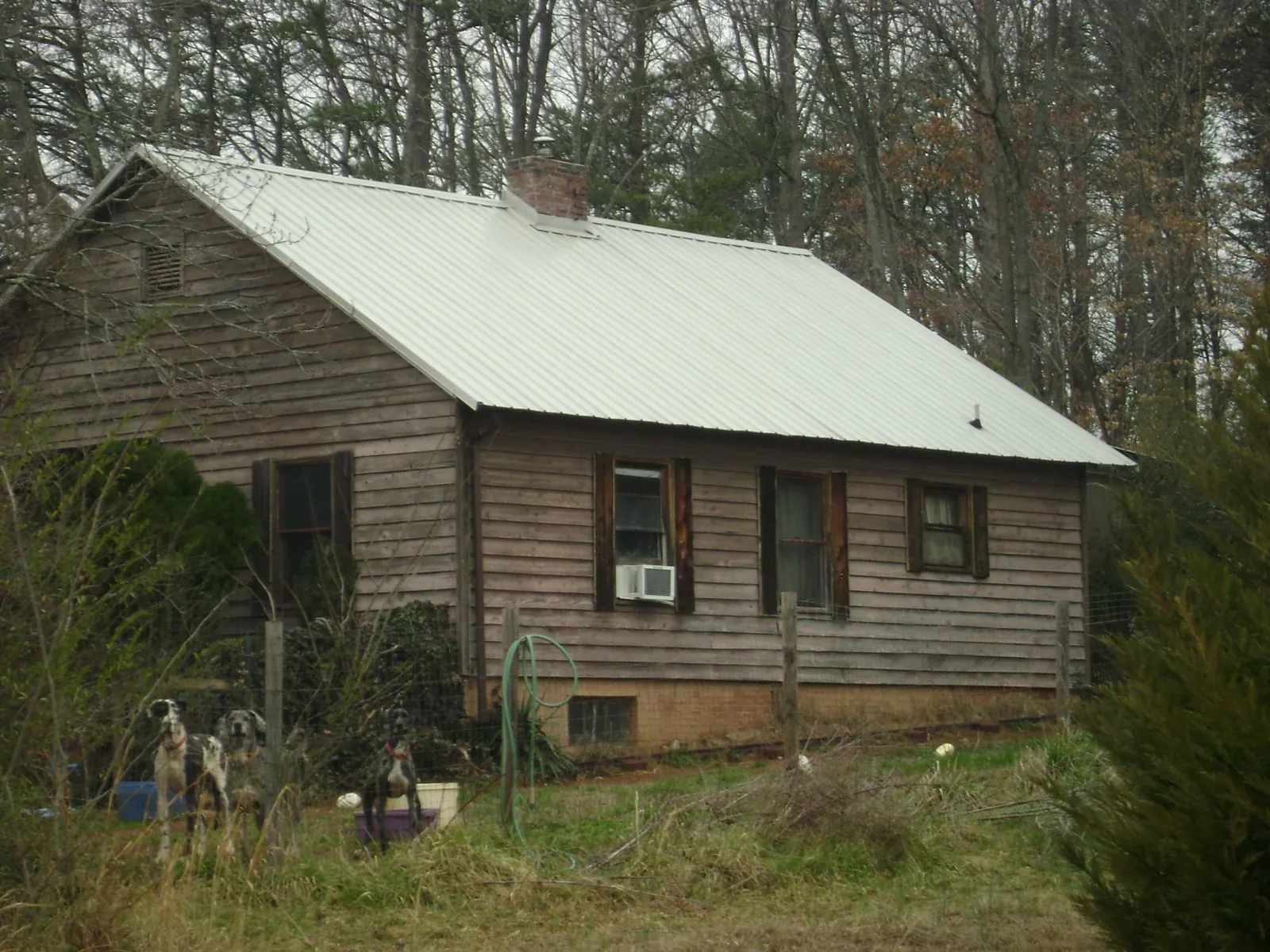 White metal roof on an old wood sided farmhouse, from a Metal Roof Installation job in Benton Harbor